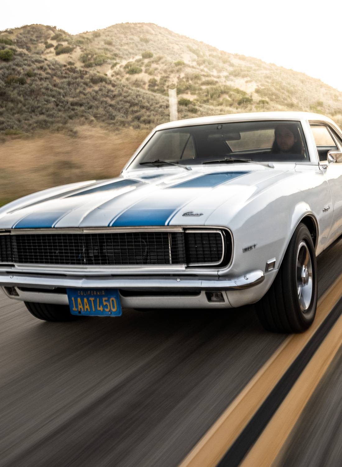 white muscle car going down the road